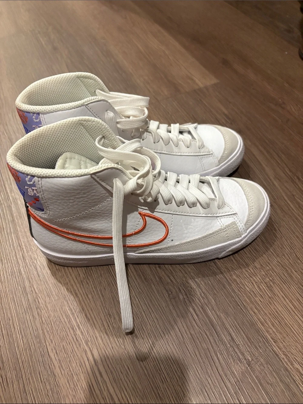 Nike Kids White High-Top Sneakers with Orange Swoosh and Purple Heel Accent